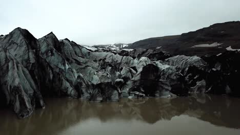 Aerial-view-of-Sólheimajökull-glacier,-Iceland,-melting-into-water,-in-summer