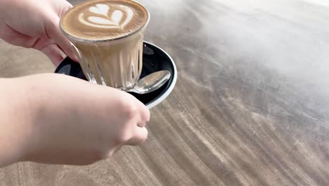 hot coffee latte is served to the table by great customer service staff member at the cafe, food and beverages hospitality industry