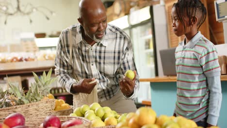 Feliz-Abuelo-Y-Nieto-Afroamericano-Mayor-Comprando-En-Una-Tienda-De-Alimentos-Saludables,-En-Cámara-Lenta