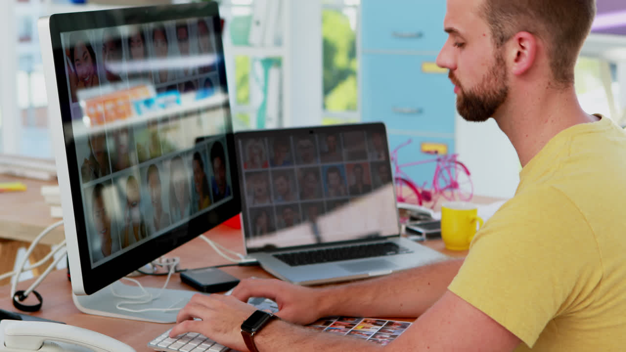 ejecutivo masculino trabajando en la computadora mientras habla por teléfono móvil 4k