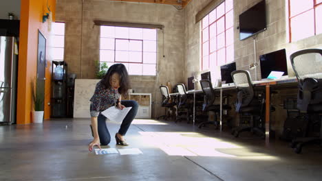 designer plans layout on floor of modern office shot on r3d