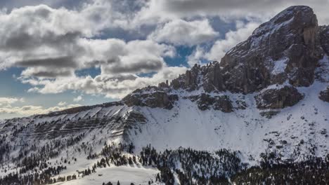 the peitlerkofel a solitary mountain standing between val badia to the east and the villnöß valley to the west, in the very north of the dolomites. snow-covered forest and hills. white clouds above.