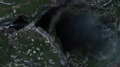 High aerial drone approaching a rocky deep hole full of total darkness, Tannourine, Lebanon