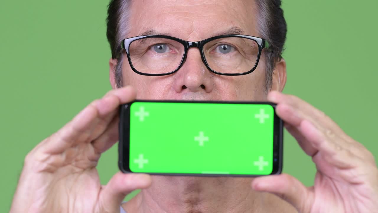 Senior handsome man showing phone