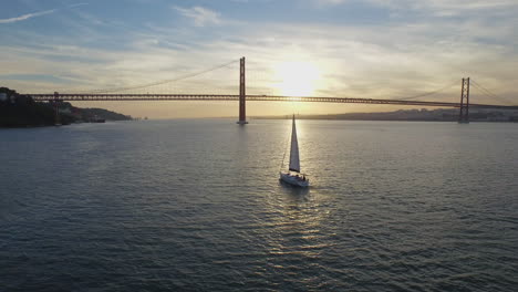 boat sailing towards sunset in lisbon