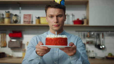 Hombre-Triste-Soplando-Velas-De-Pastel-Sentado-Solo-En-La-Cocina-De-Cerca.-Chico-Celebrando.