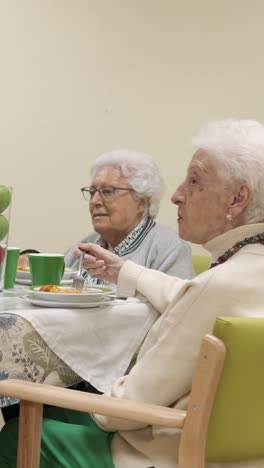 crop worker serving pasta in plate for elderly people