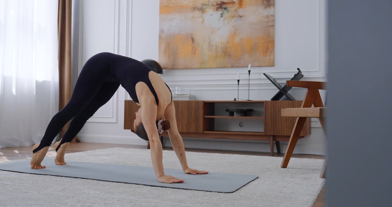 Young Woman Practicing Yoga and Pilates Exercises at Home