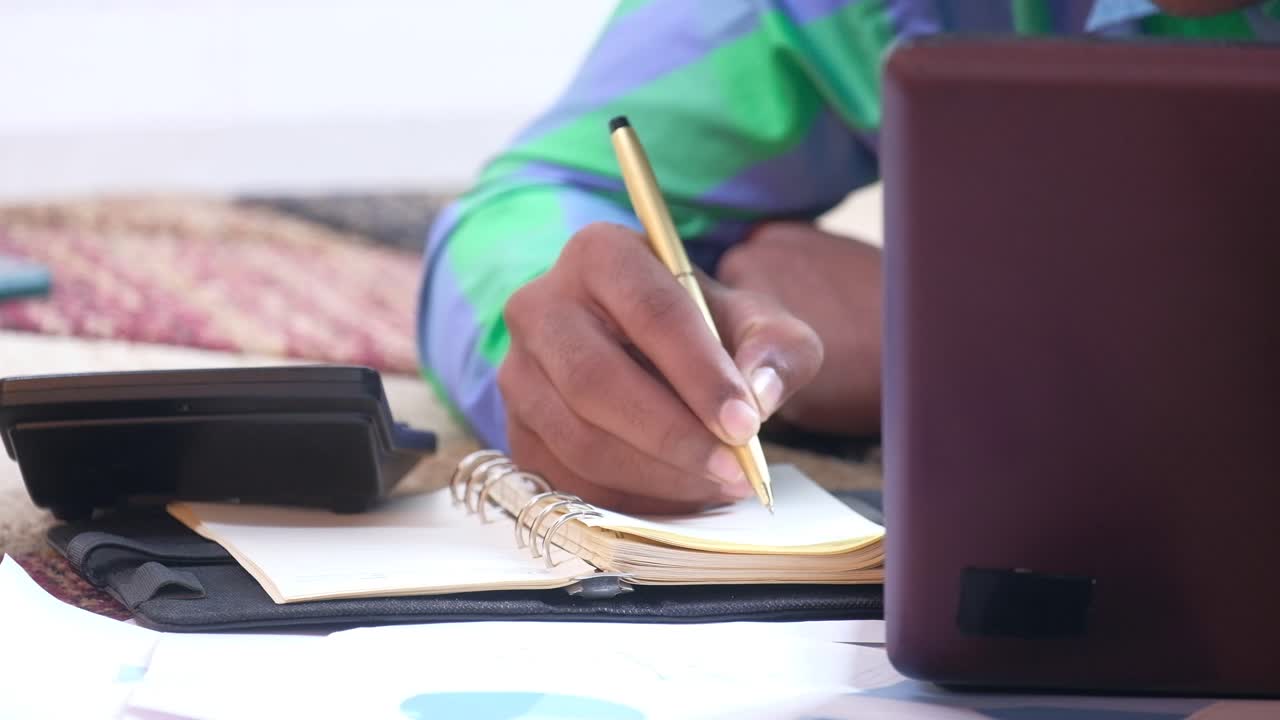 persona que trabaja en una computadora portátil y toma notas