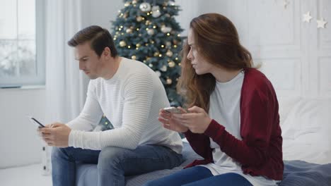 familia ocupada buscando teléfonos inteligentes en casa privada. pareja casada usando teléfonos