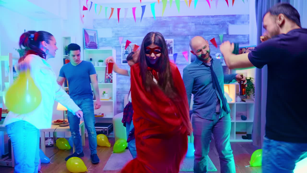 haz un zoom en la foto de una chica vestida de superhéroe con una capa roja en la fiesta de sus amigas.