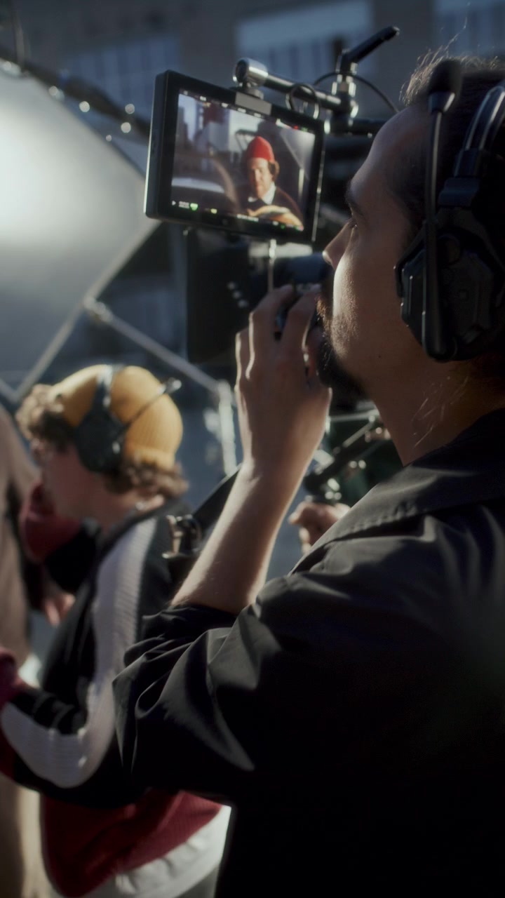 Verticale: Operatore di ripresa che guarda lo schermo del monitor di campo su un set cinematografico