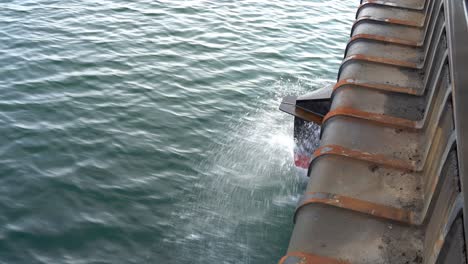 ships bow penetrating through sea surface while moving ahead - closeup detail of bow with water splashing around