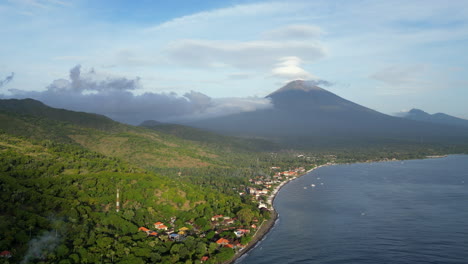 mount agung looks down on amed beach village in mid morning sun in bali indonesia