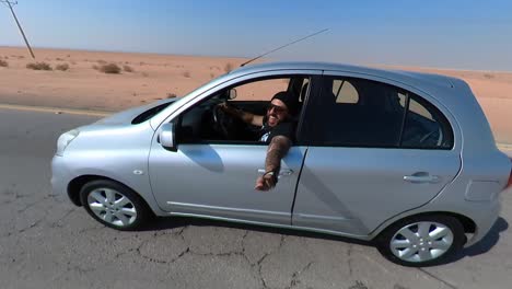 man driving through the desert