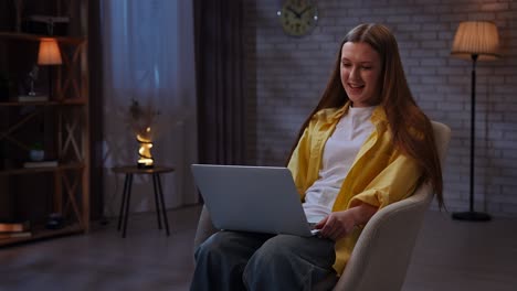 mujer joven trabajando en la computadora portátil por la noche