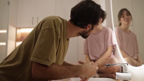 pareja lavándose las manos en el baño