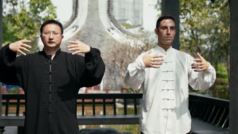 two men practicing tai chi outdoors