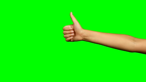 persona haciendo un gesto de la mano de los pulgares hacia arriba contra el fondo de la pantalla verde