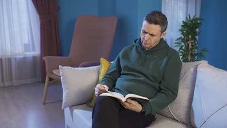 El-Hombre-Está-Leyendo-Un-Libro-En-El-Sofá-De-Casa.-Aprendizaje,-Lectura-De-Libros,-Concepto-De-Descanso-En-Casa.