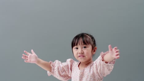 child with arms up happy and laughing with sweet dirt on face