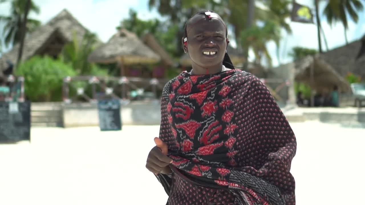 Un joven tribal mirando a la cámara en un día ventoso en la playa