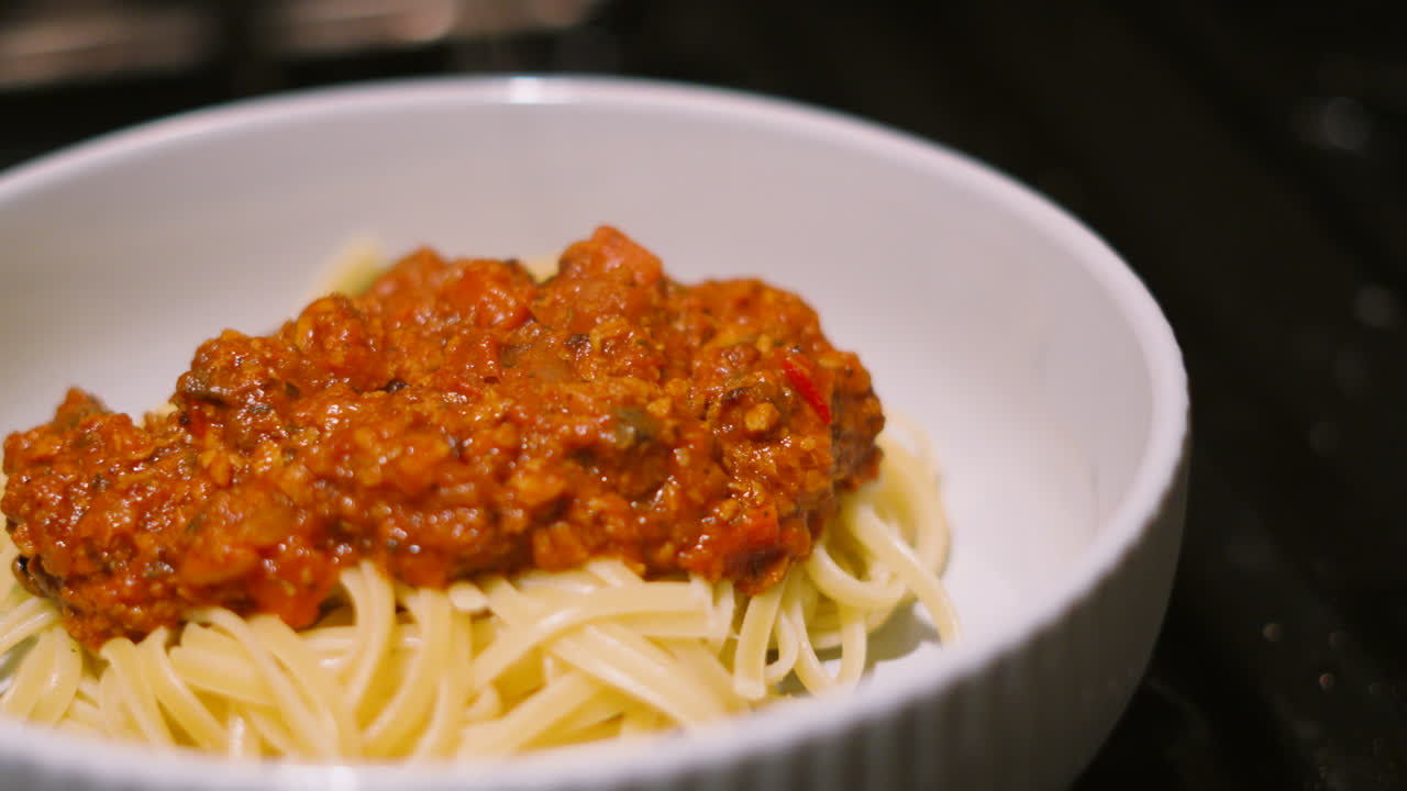 Delicious Spaghetti Bolognese Pasta Dish in Bowl Ready to Eat. Italian Food Traditional Classic Cuisine Made with Beef Mince and Vegetables including Mushrooms, Peppers, Onions 4K.