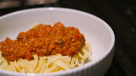 delicious spaghetti bolognese pasta dish in bowl ready to eat. italian food traditional classic cuisine made with beef mince and vegetables including mushrooms, peppers, onions 4k.