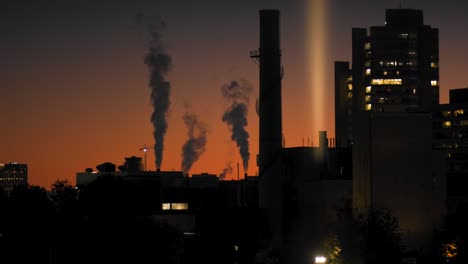 disparo estático de tiempo cercano de las emisiones que salen de una fábrica en una ciudad