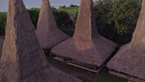 Close-up-of-traditional-village-unique-roofs-at-Sumba-island-during-sunrise,-aerial