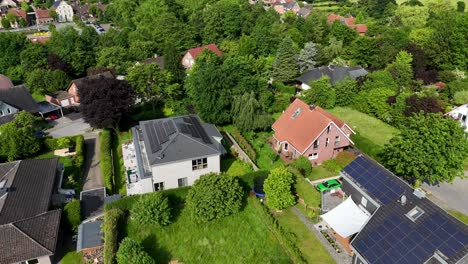 noble residential apartment house with solar panels on roof during sunny day. aerial orbit shot. spring day in america. white facade with terrace and balcony. production of green energy.
