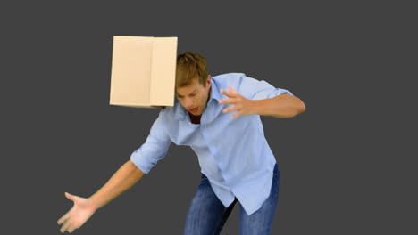 clumsy man dropping boxes down on grey screen