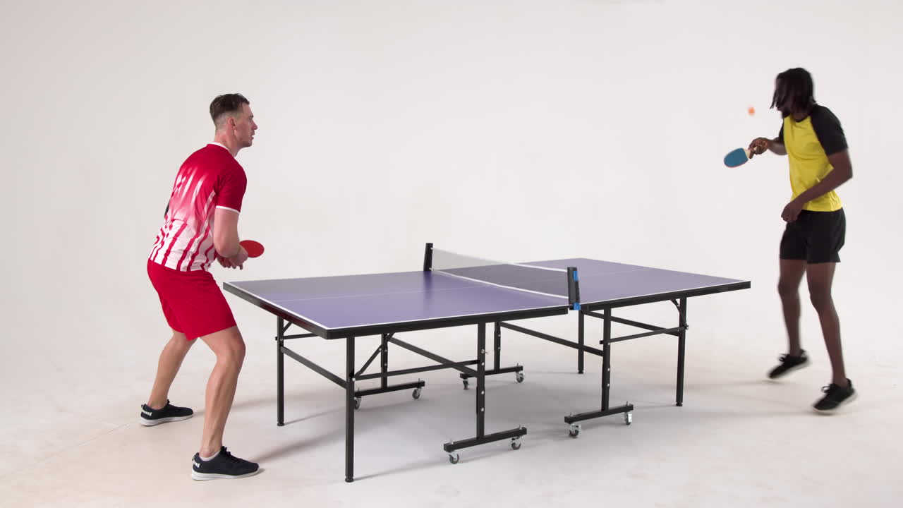 Multiracial male table tennis players serving and passing the ball to each other on white background