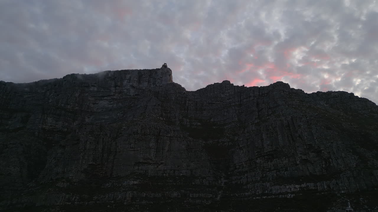 tiro de drone al atardecer de nubes rosadas sobre la montaña de la mesa en ciudad del cabo, sudáfrica