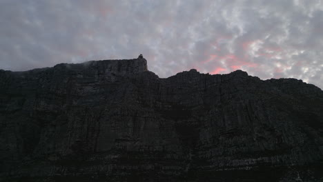 sunset drone shot of pink clouds above table mountain in cape town, south africa