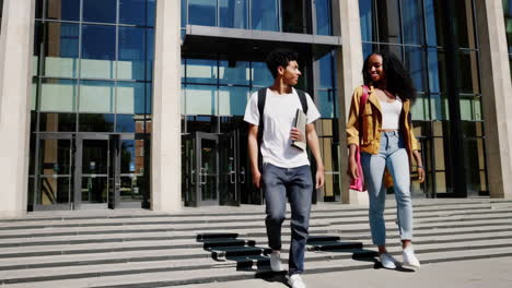 two students walking down stairs at a modern university building