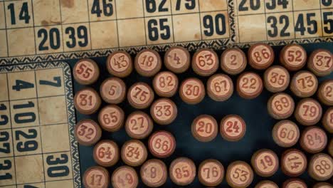 Cinematic-close-up-smooth-tilt-down,-shot-from-above-of-a-Bingo-wooden-barrels-in-a-circle,-woody-figures,-old-numbers-background,-vintage-board-game,-professional-lighting,-slow-motion-120-fps