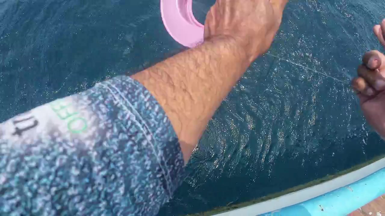Punto de vista de las manos de un pescador tirando de un sedal de nailon del agua del mar.