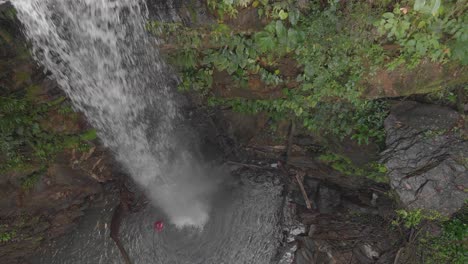 aerial footage of a cascading waterfall over a rock formation