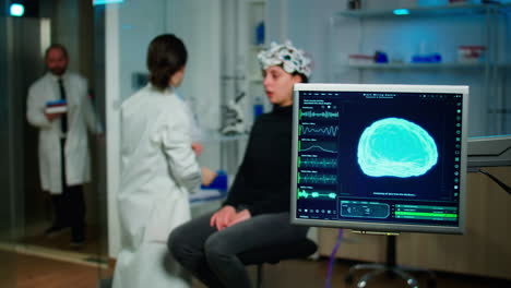 investigador médico que prepara al paciente para el examen de las funciones cerebrales