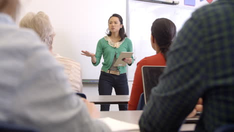 female asian teacher with tablet takes adult education class