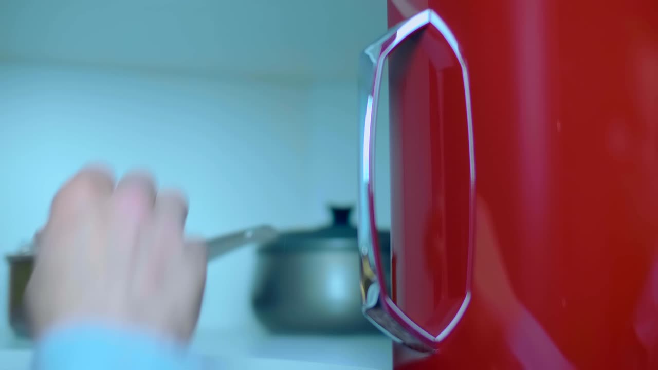 한 남자가 부 캐비의 문을 열고 금속 판을 가져갑니다.