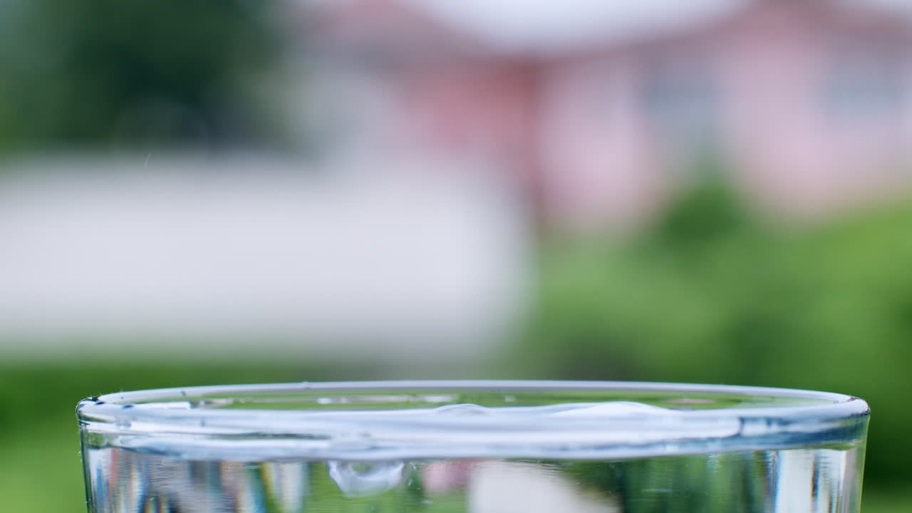 las gotas de agua se forman cuando el agua cae en un vaso lleno de agua limpia y clara