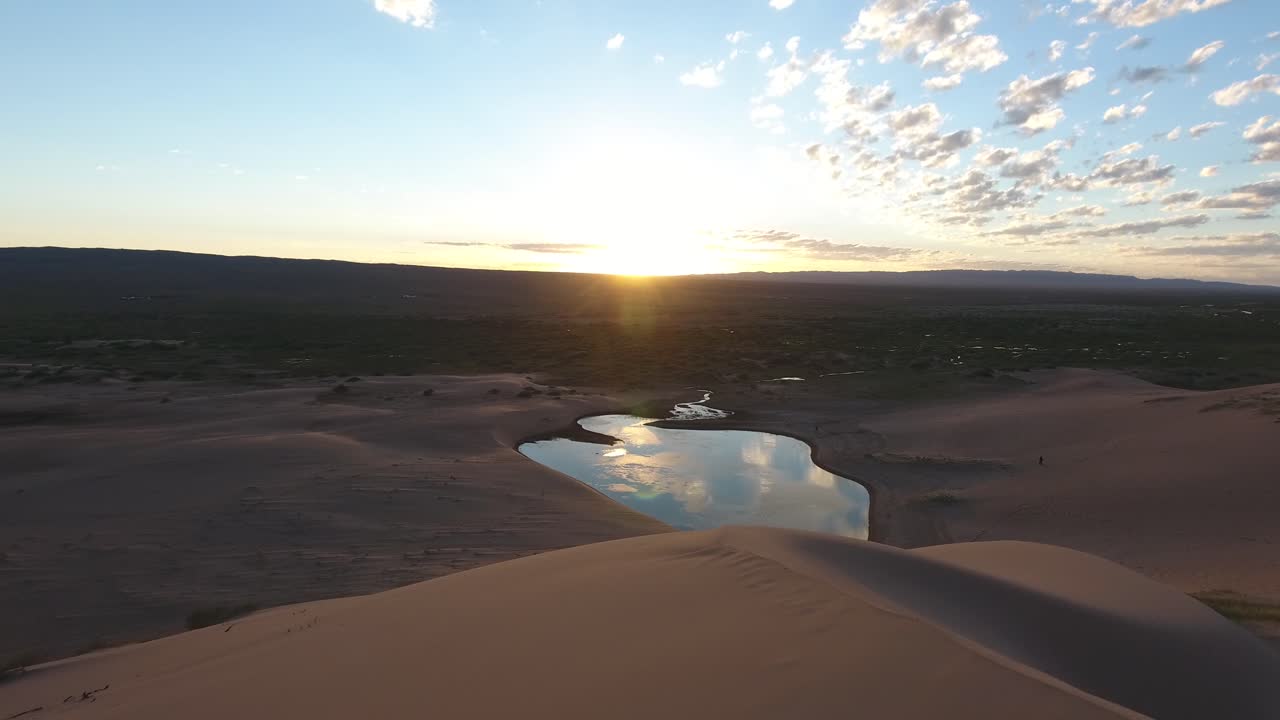 drone aéreo disparado en el desierto de gobi siguiendo la duna de arena hacia un hermoso oasis