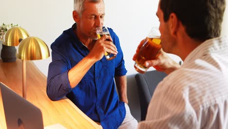 dos hombres brindando vasos de cerveza