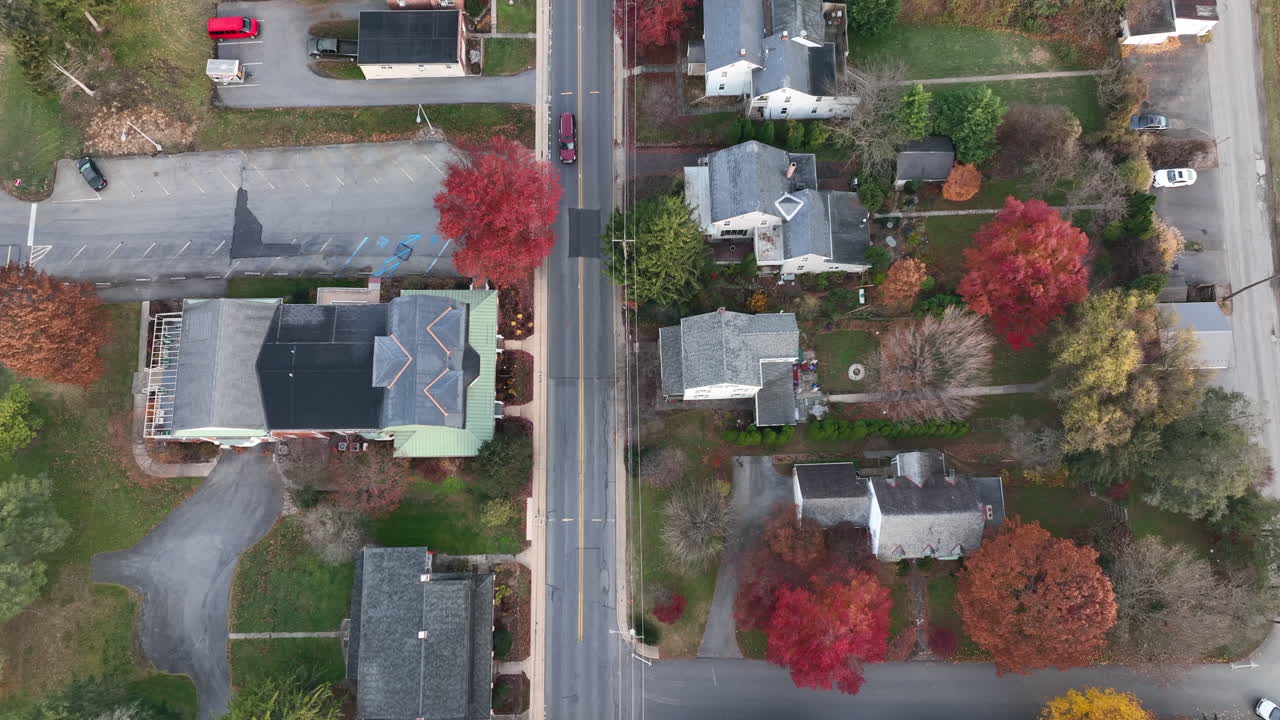 형형색색의 가을 나무가 있는 교외 주택의 하향식 공중
