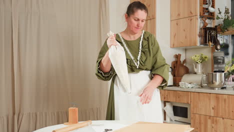 baker preparing for cupcake baking, drops rubber jug on counter, organizing workspace, and getting ready for baking with cozy kitchen setting, warm lighting, and rustic decor