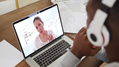 African-american-male-college-student-wearing-headphones-having-a-video-call-on-laptop-at-home