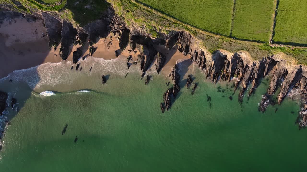 Coumeenoole Beach glowing under bright sunshine, with clear skies and turquoise waves - Dingle Co.Kerry - 4K Cinematic Drone Footage 03