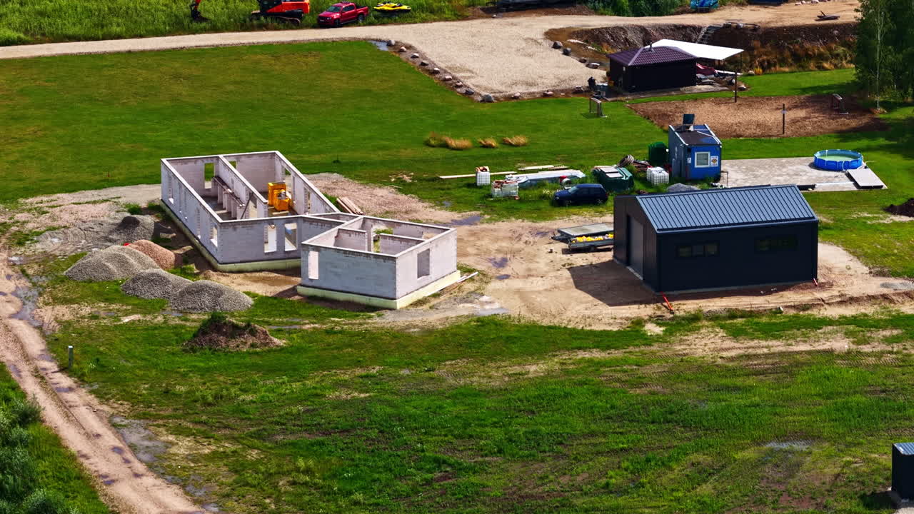 Construction Site with Unfinished House and Excavator